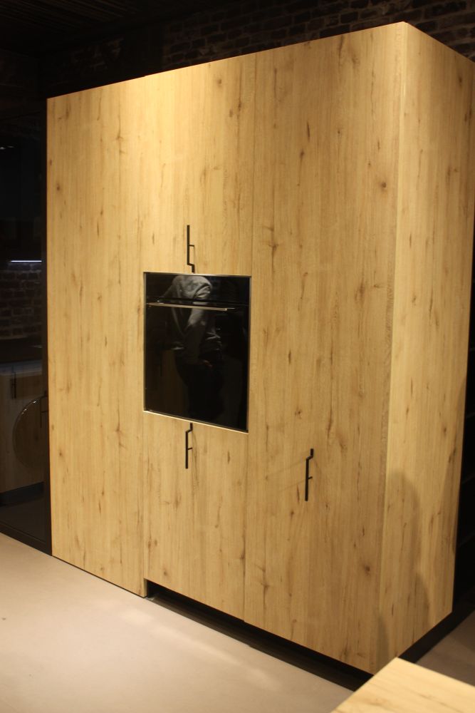 Aran possède cette unité où de belles armoires en bois cachent de nombreux appareils électroménagers et sont dotées d'une quincaillerie verticale unique.