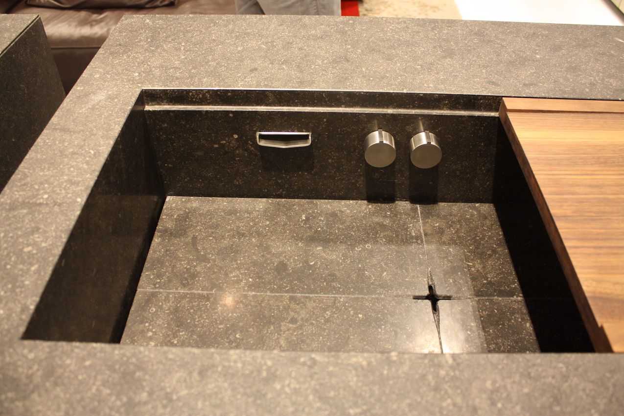 Stenninger propose une version élégante où les boutons et le robinet se trouvent sous la surface du comptoir, et comprend un panneau de bois coulissant.