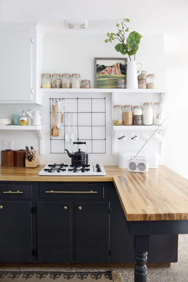 Armoires noires dans une cuisine avec des comptoirs en bois